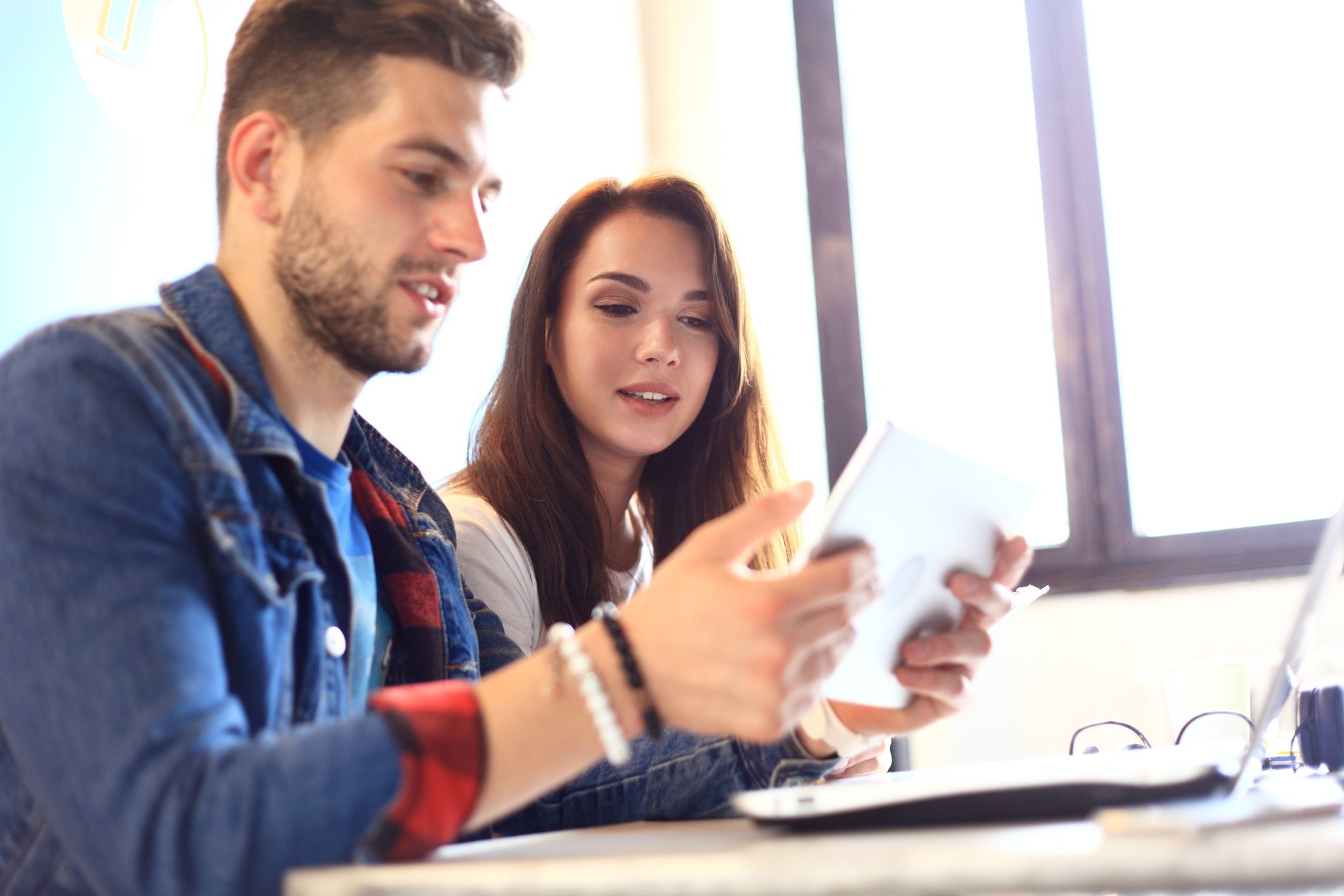 Two young employees using a tablet in the office